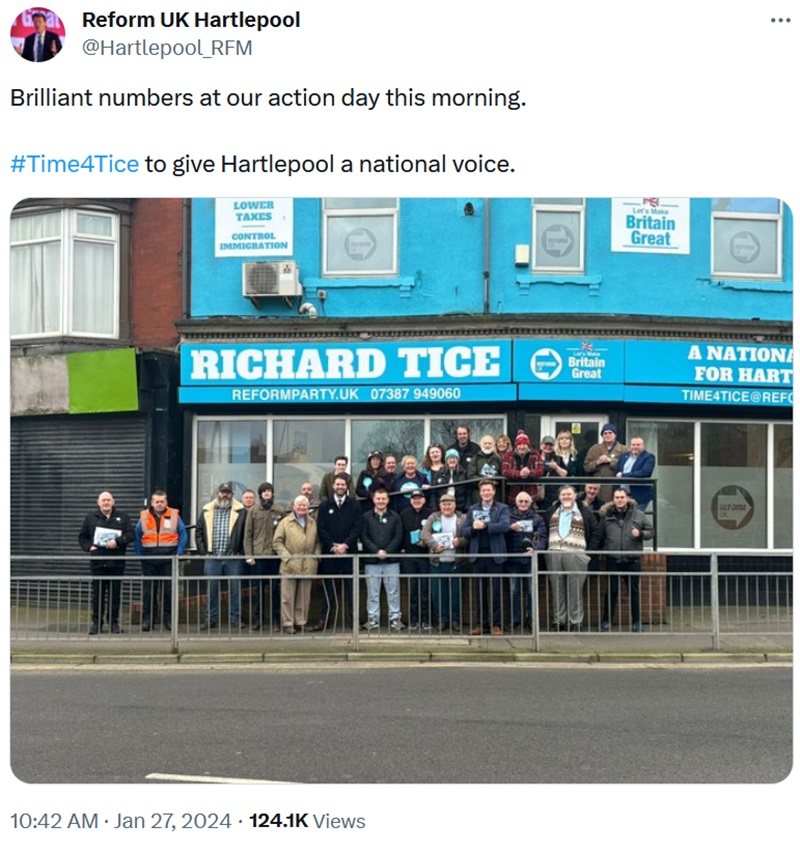 A group ofabout 25  people standing by Richard Tice outside his headquarters. 